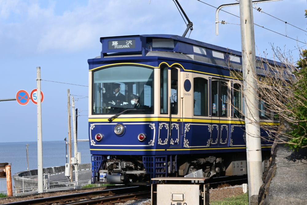 江ノ電海をバックに 青のラッピング車両